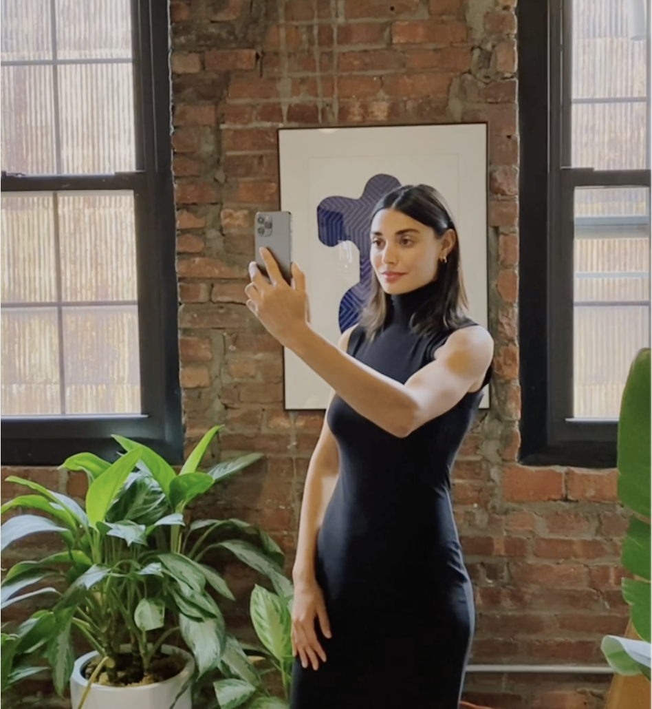 Woman in a black dress taking a selfie