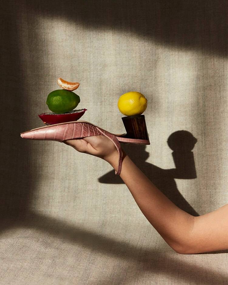 Editorial still-life photography for footwear marketing campaign with playful styling and dramatic lighting