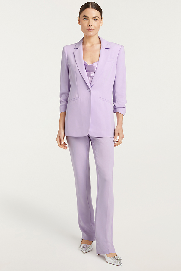 Simple, on-figure image of a model in a purple suit post-retouch, color-corrected, refined finish.