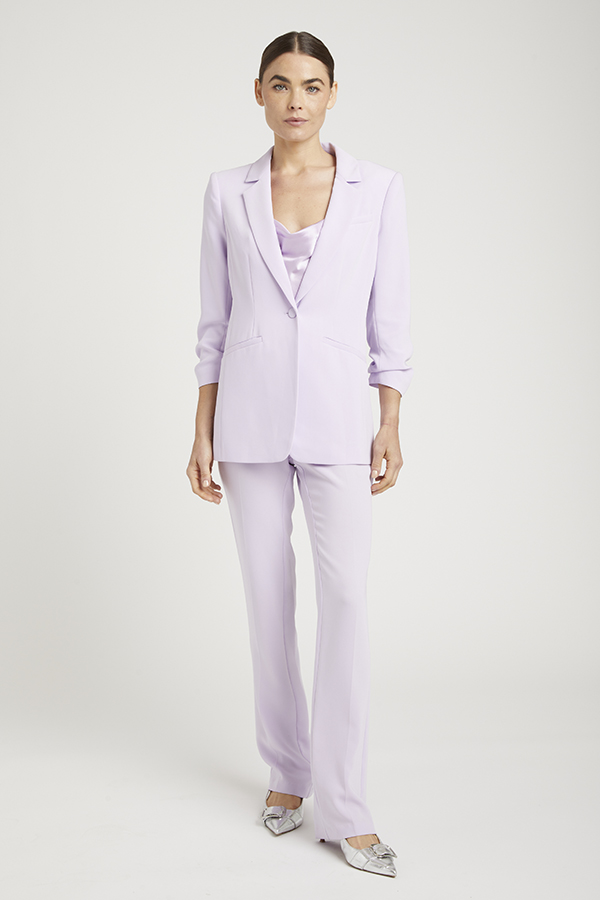 Simple, on-figure image of a model in a purple suit pre-retouch, natural state.