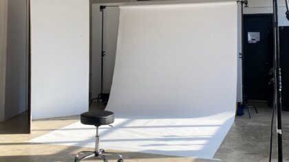 Photography setup with white background and lighting equipment, showing the preparation for an e-commerce photoshoot.