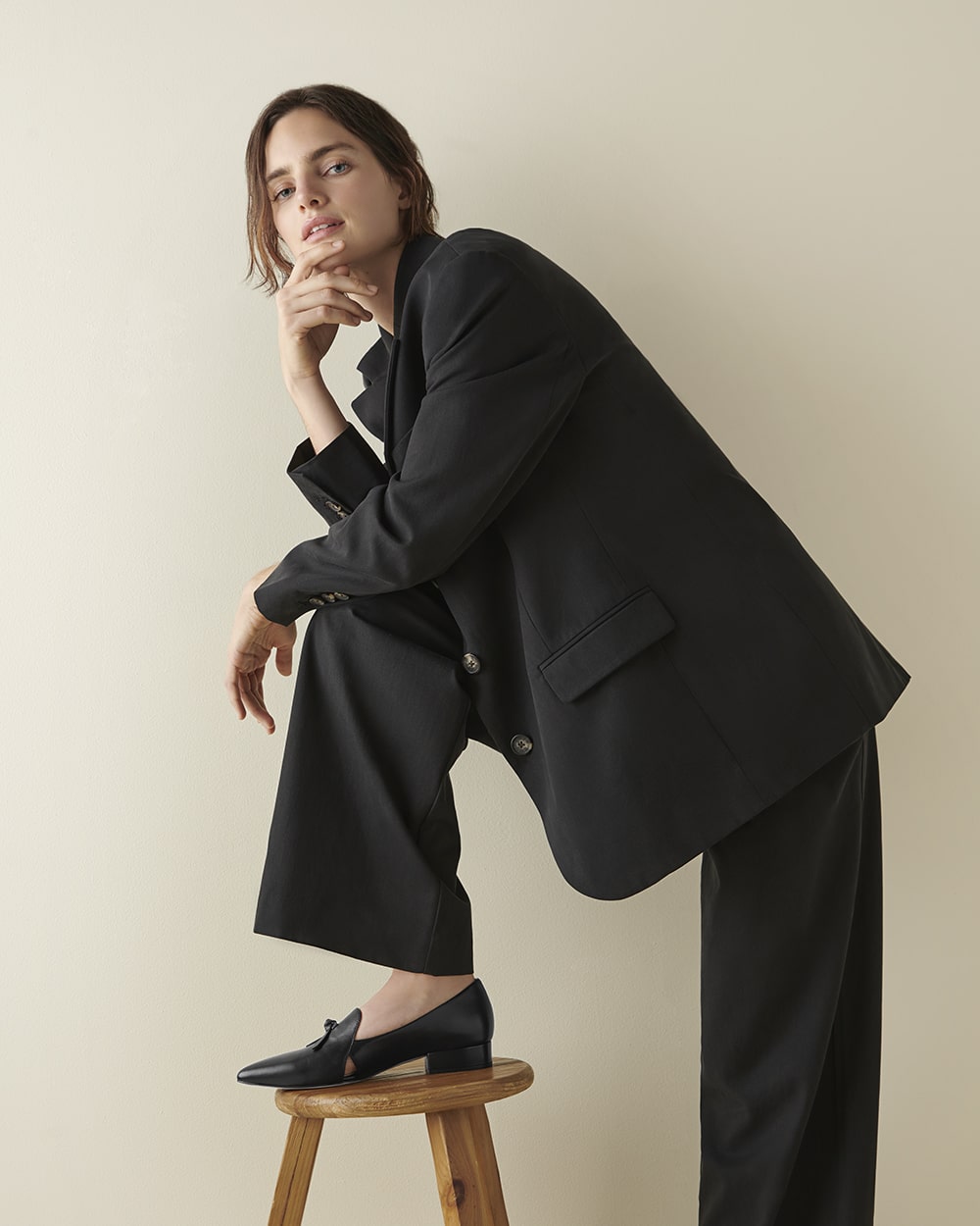 Model in a black suit, showcasing sleek and professional women's fashion for online retail