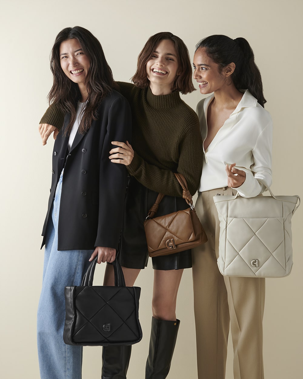 Group e-commerce shot featuring three models carrying luxury Cole Haan handbags, styled for a contemporary look.