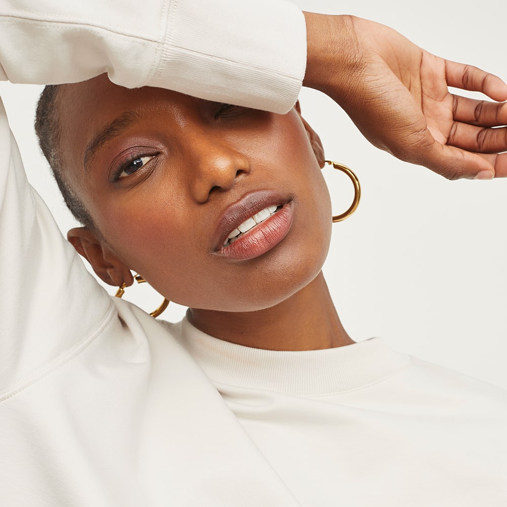 Close-up portrait of a model in a white top, highlighting natural beauty for e-commerce fashion imagery