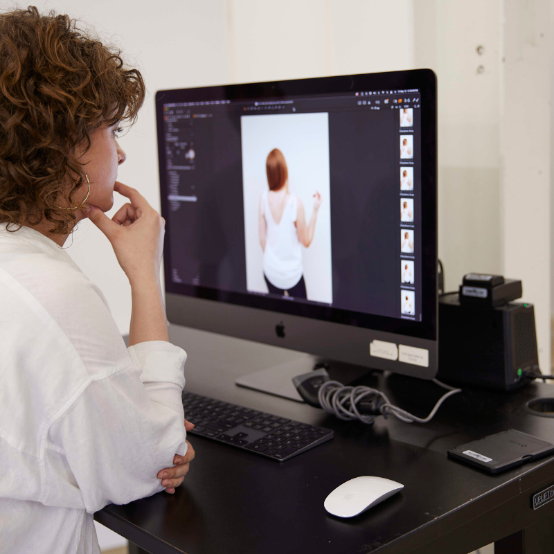 Creative director reviewing e-commerce photos on a desktop, ensuring visual alignment with brand storytelling goals